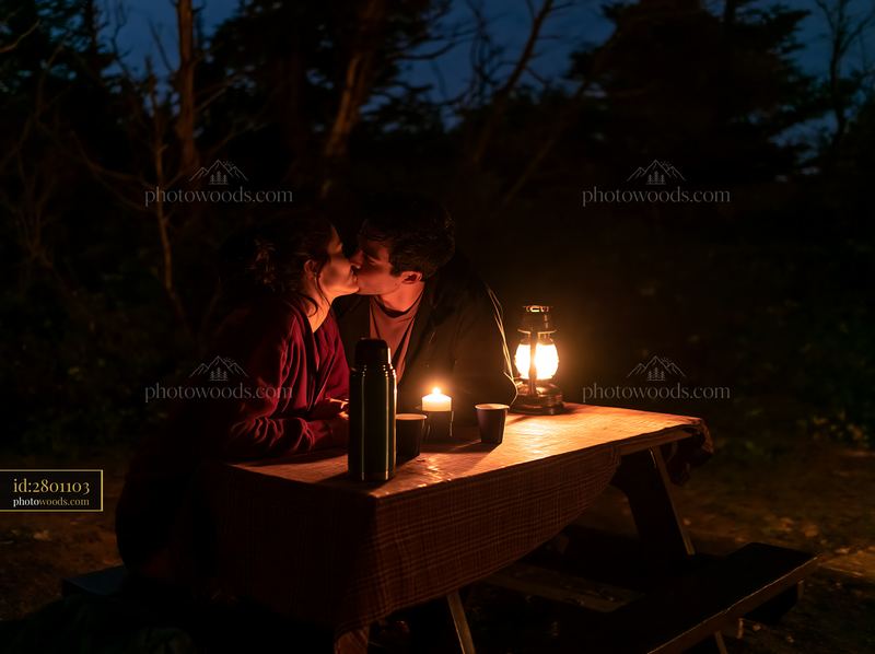 Lovers kissing on a mountain overlook at night