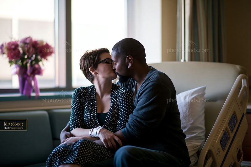 Kiss on forehead between partners in hospital setting