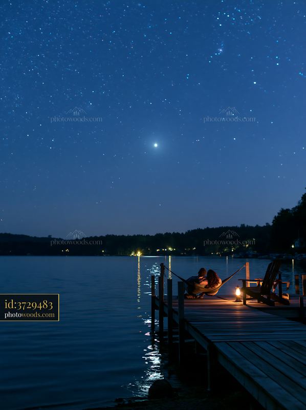 Couple relaxing in a hammock under stars by the lake