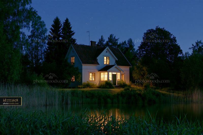 House beside a starry lake at night