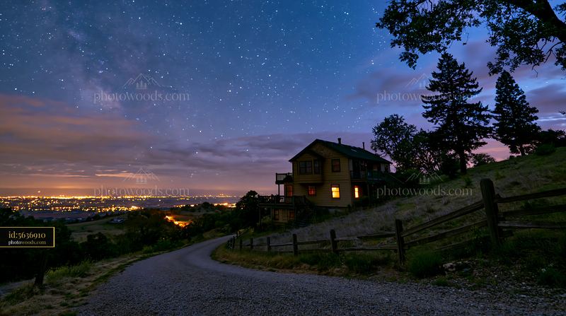 House under stars with gravel driveway near hillside