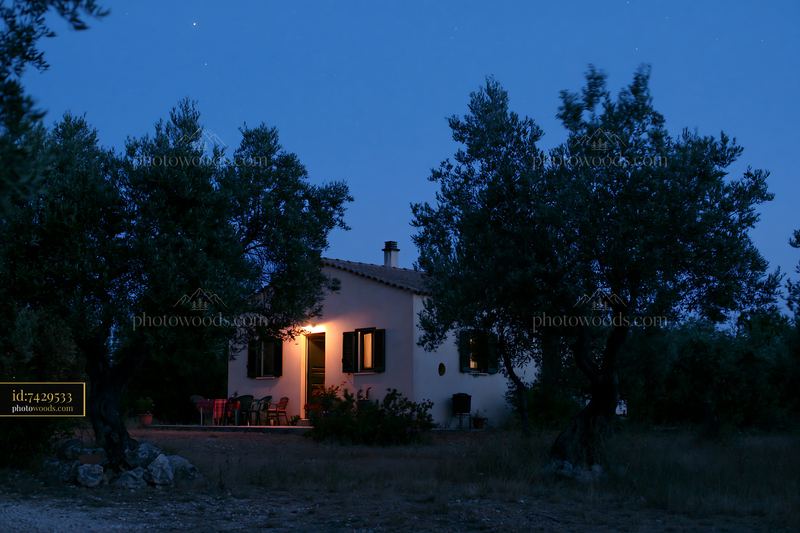 House under stars with warm light during blue hour
