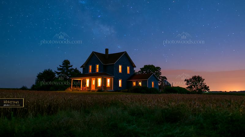 House under a starry sky with warm lights shining from windows