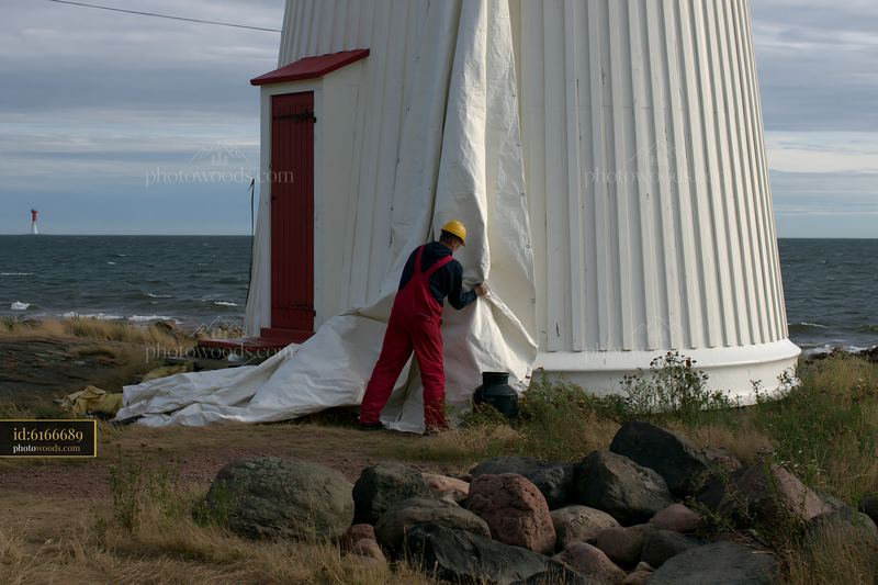 Lighthouse maintenance worker at work near the coast