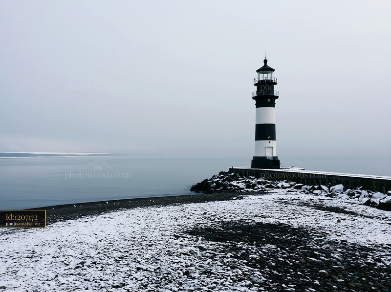 Lighthouse with black and white stripes by the shore