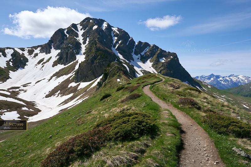 High mountain ridge with snow patches under a clear blue sky