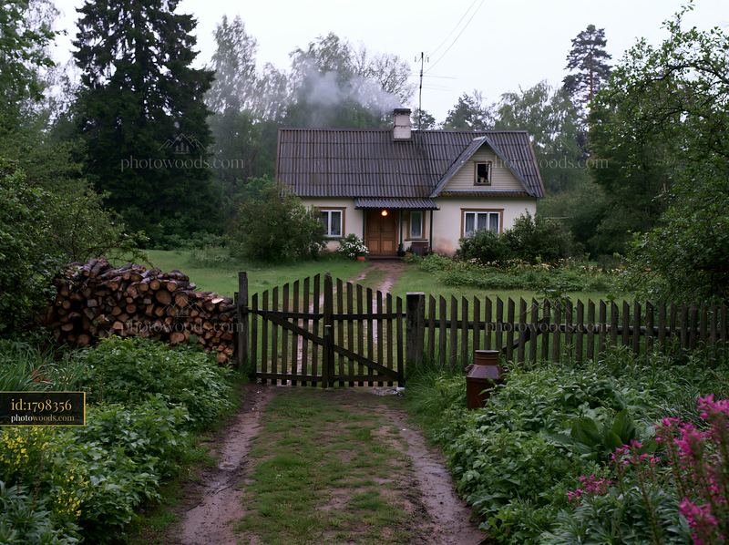 Rural cottage with chimney smoke in a green setting