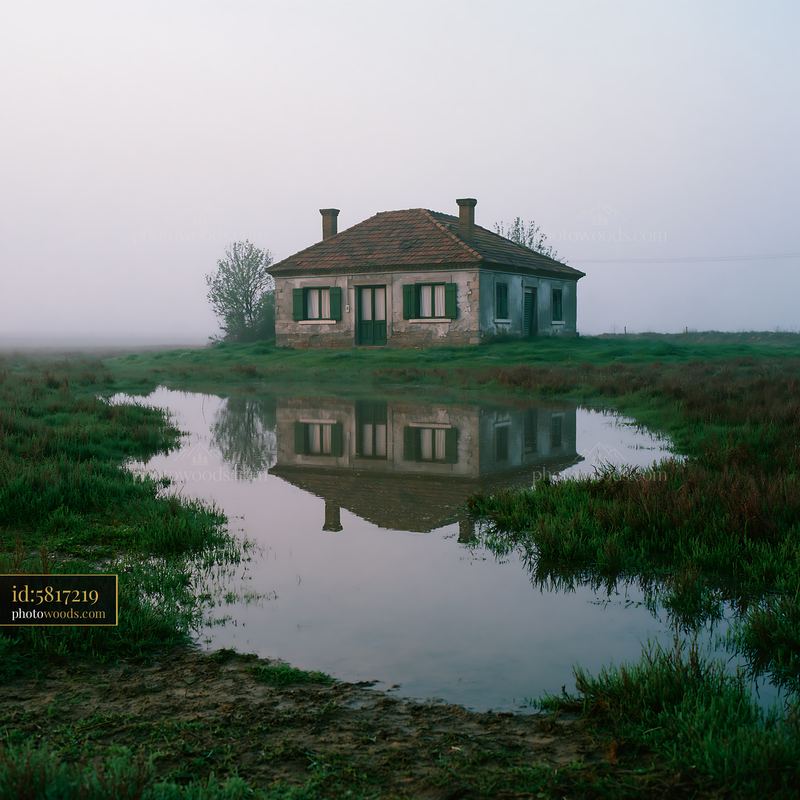 Rural farmhouse surrounded by fog and water reflections
