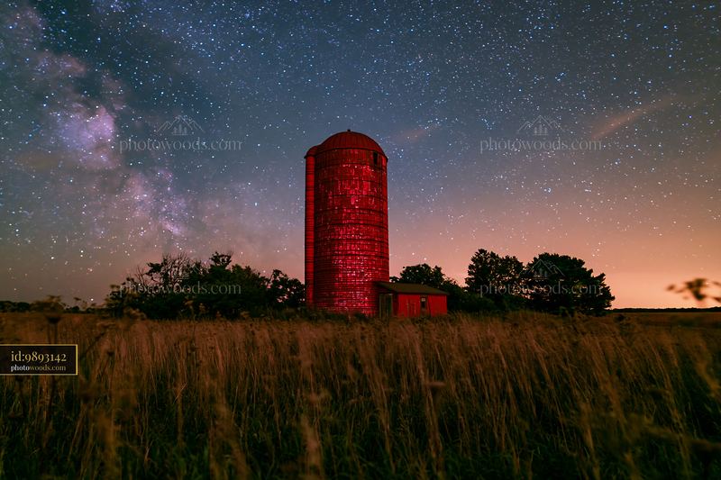 Starry night over a rural silo with a bright milky way