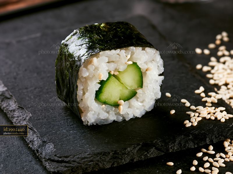 Single sushi piece on black slate plate