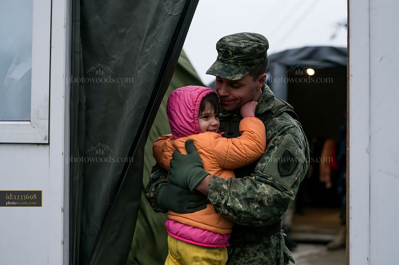 Soldier embraces child in a military setting