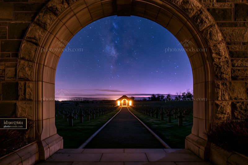 Soldiers' cemetery under a starry night with an archway view
