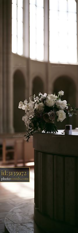 Wedding bouquet and ring box on altar in bright church