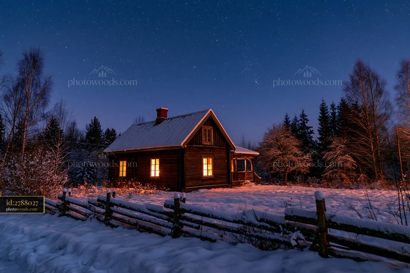 Snowy house under stars with warm light glowing from windows