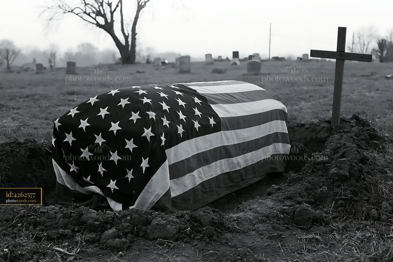 American flag-draped coffin beside open grave in cemetery