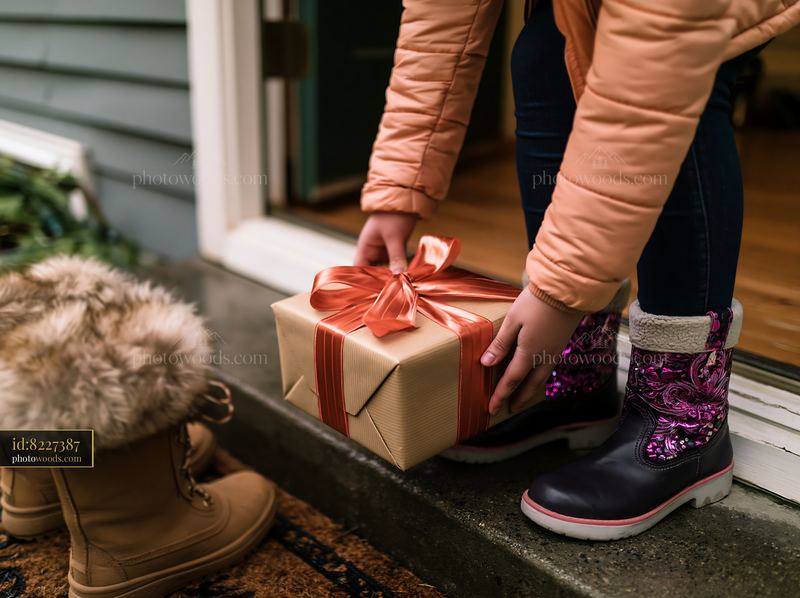 Child placing wrapped Christmas gift at a home doorstep