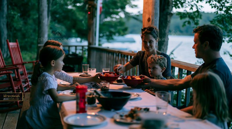 Family sharing dessert together after dinner by a lakeside