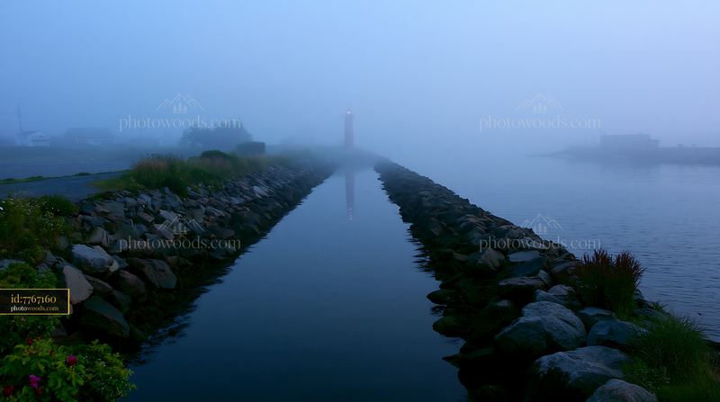 Lighthouse and rocky channel in heavy ocean fog