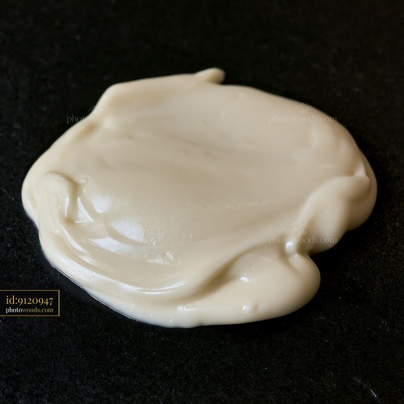 Cream dose with matte texture on a black surface