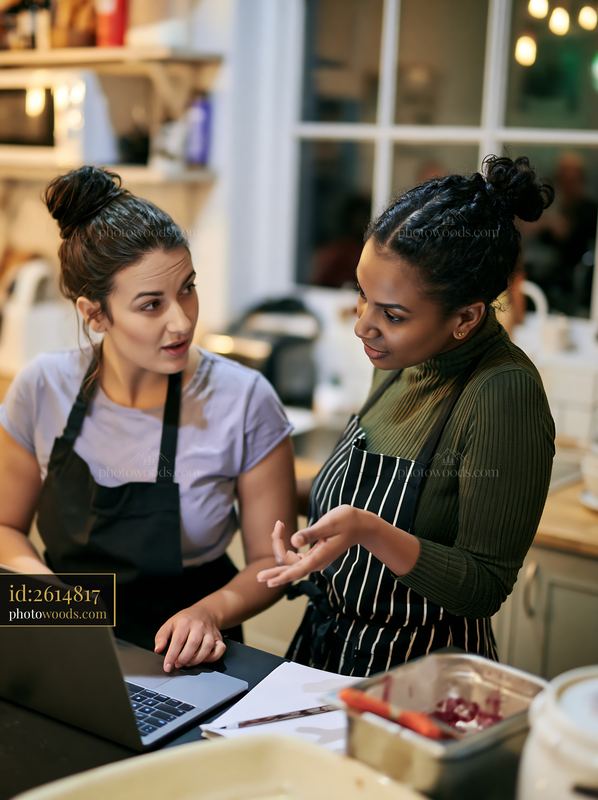 Businesswoman discussing deadlines with colleague in a kitchen