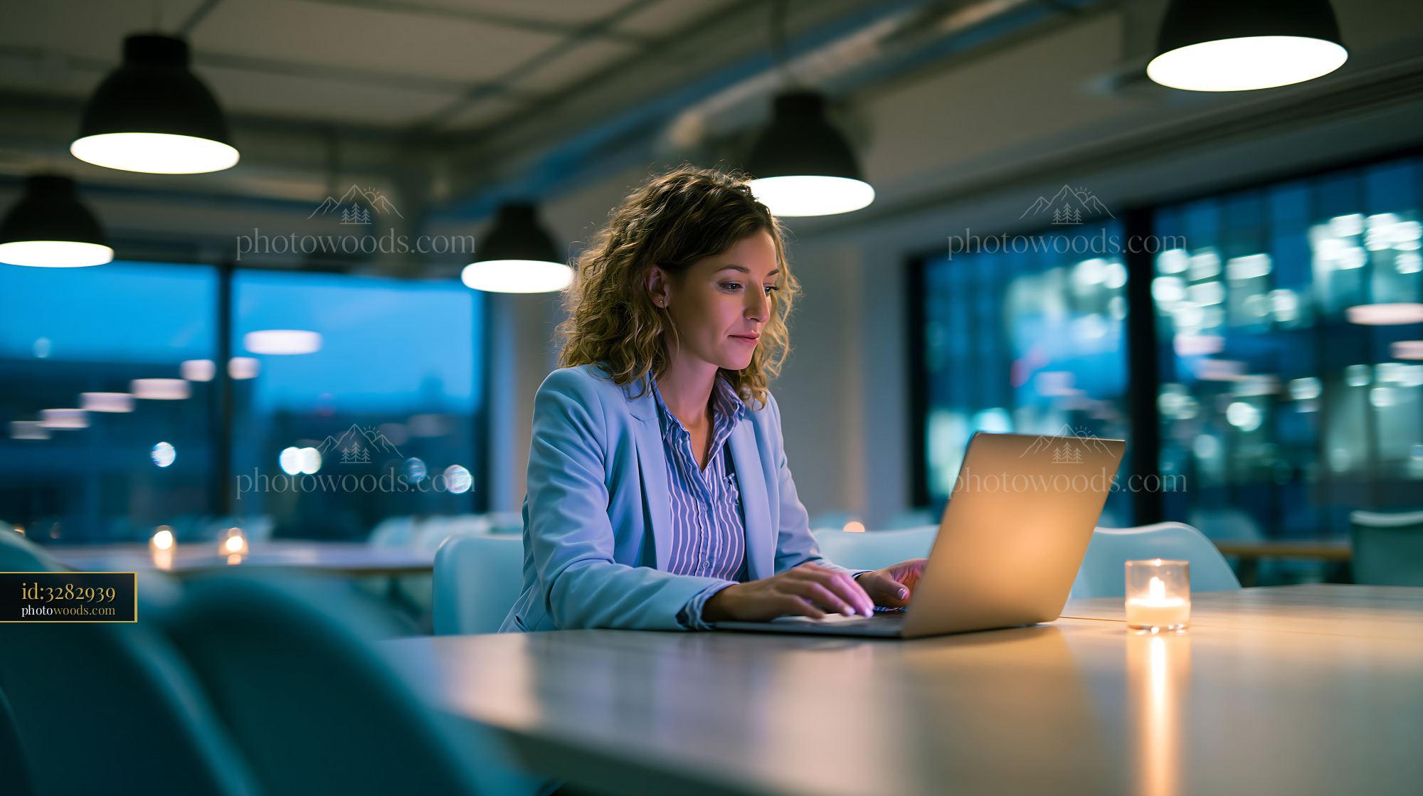 Employee Working Late at a Desk With a Laptop in a Modern Office