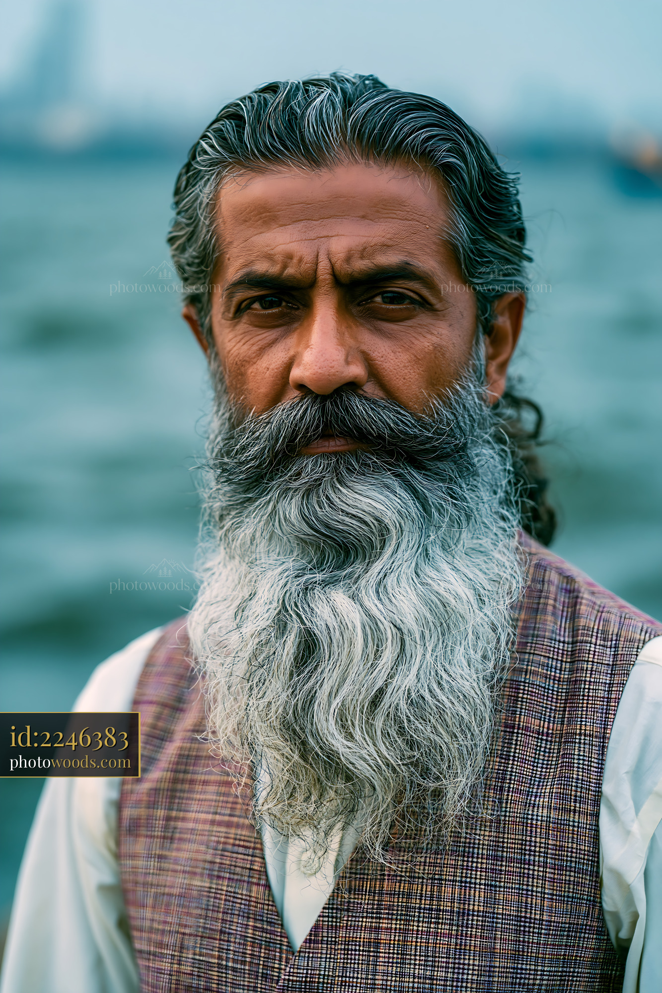 Man With Long Beard Standing by Water With a Serious Expression