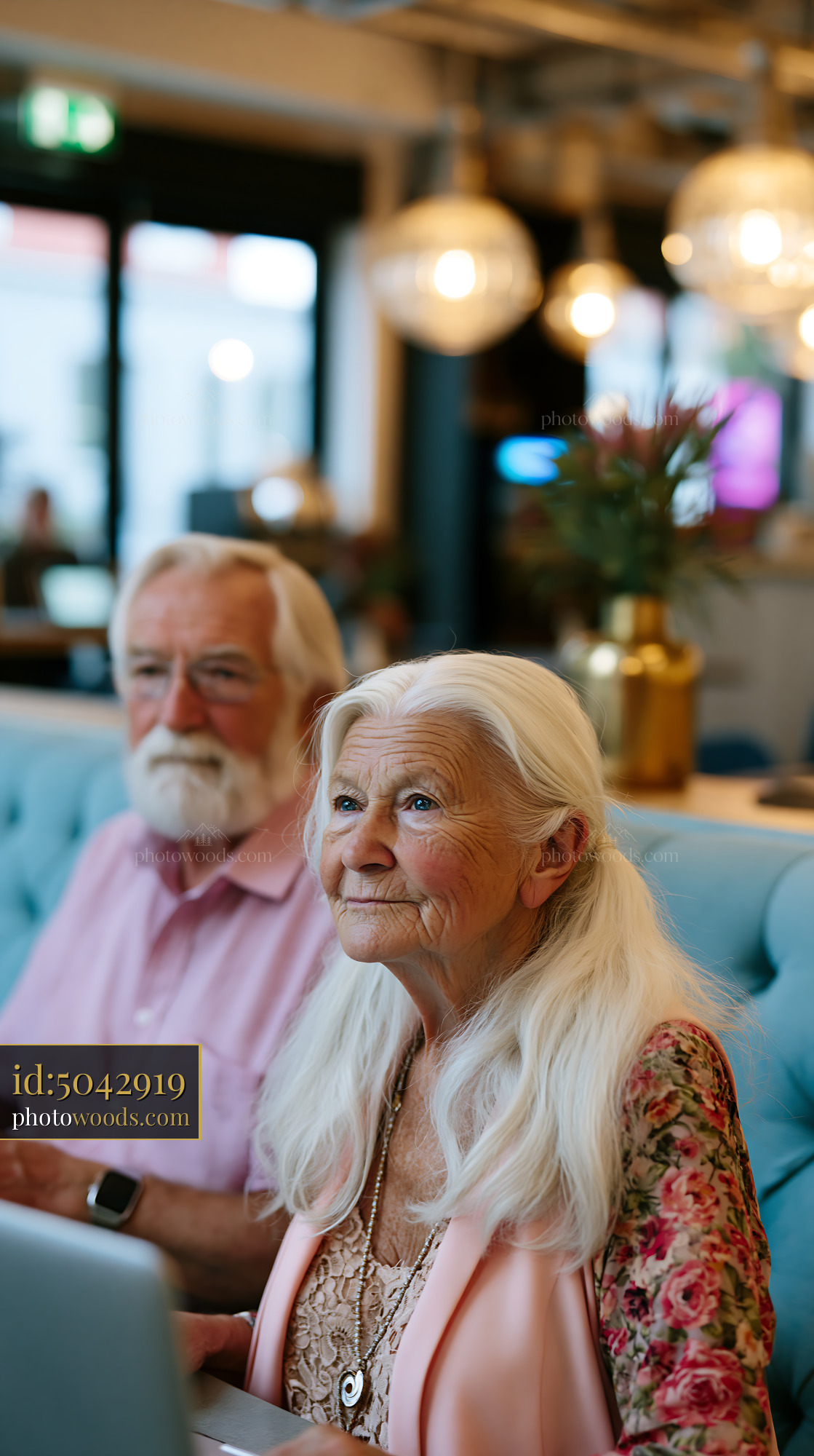 Elderly Couple Working Together in a Modern Cafe Setting