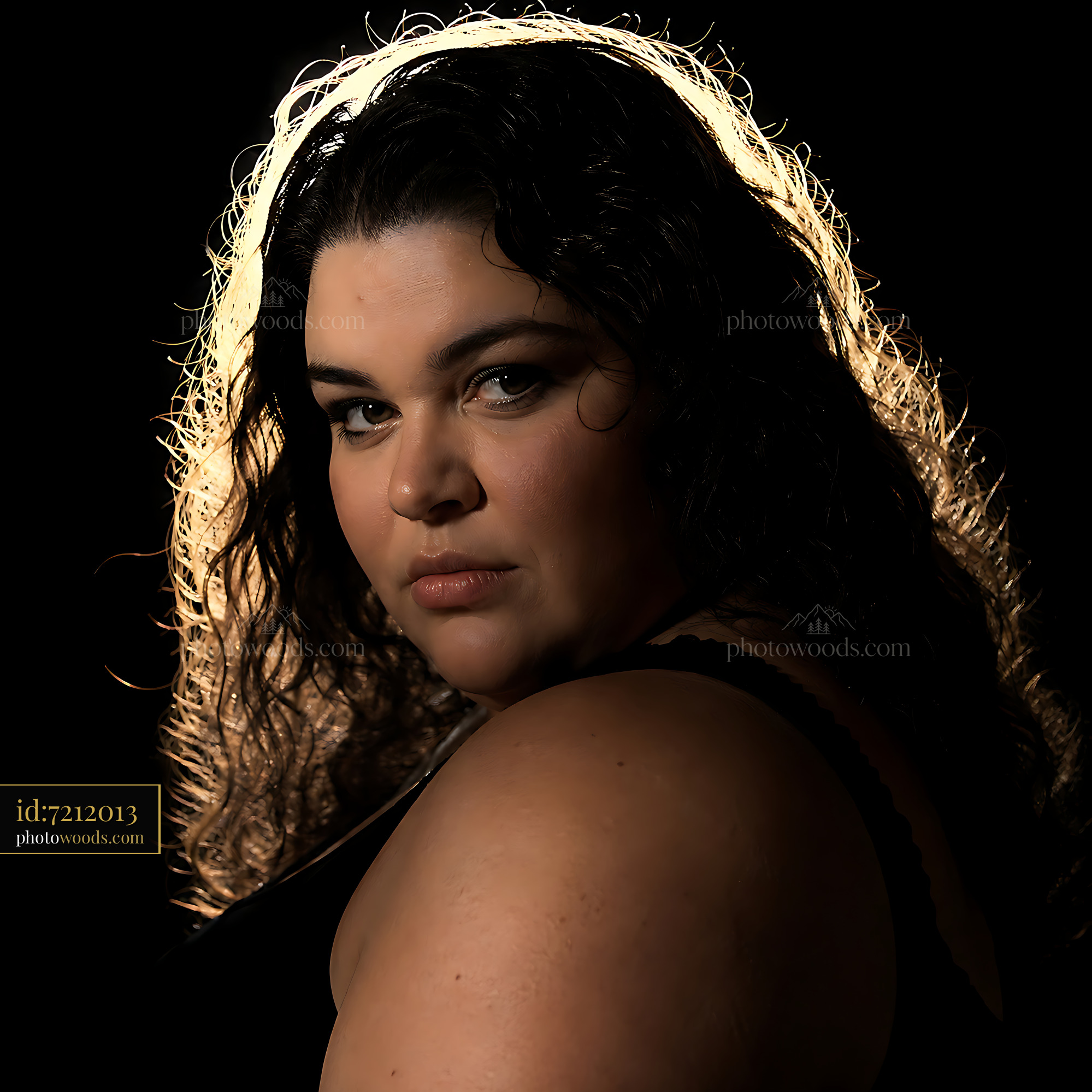 Woman With Curly Hair Looks Over Shoulder in Dim Light