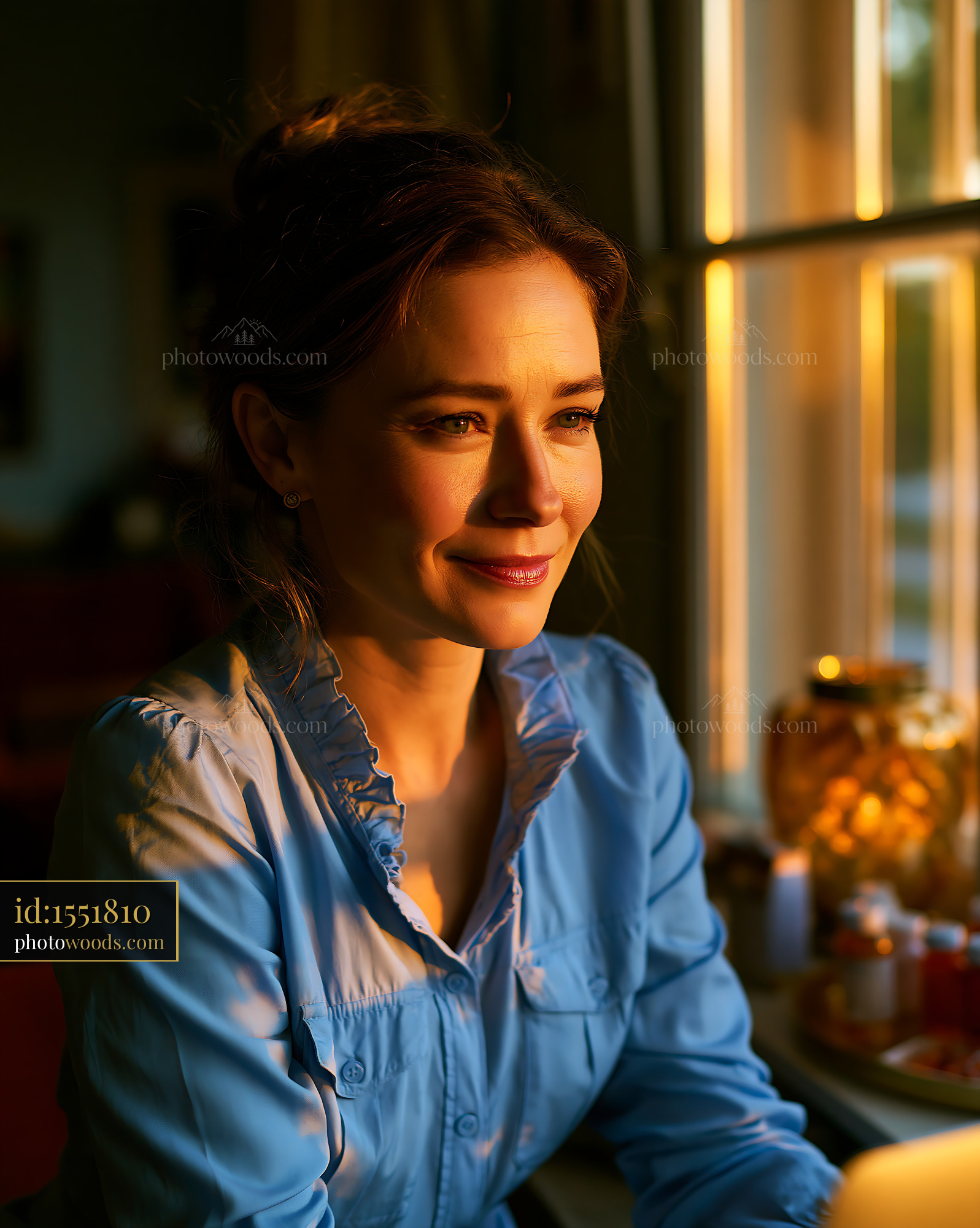 Woman in Blue Shirt Sitting by Window During Golden Hour