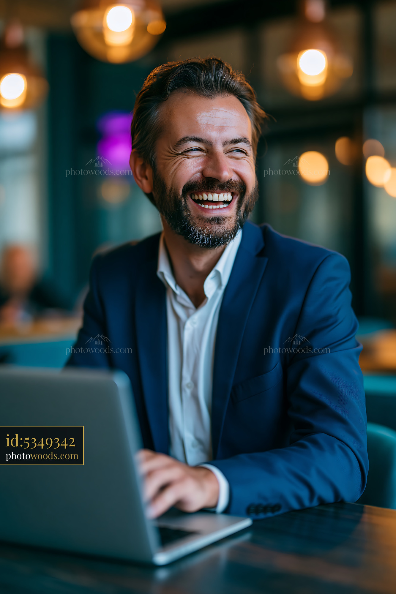 Businessman Works on Laptop and Smiles in Modern Office Space