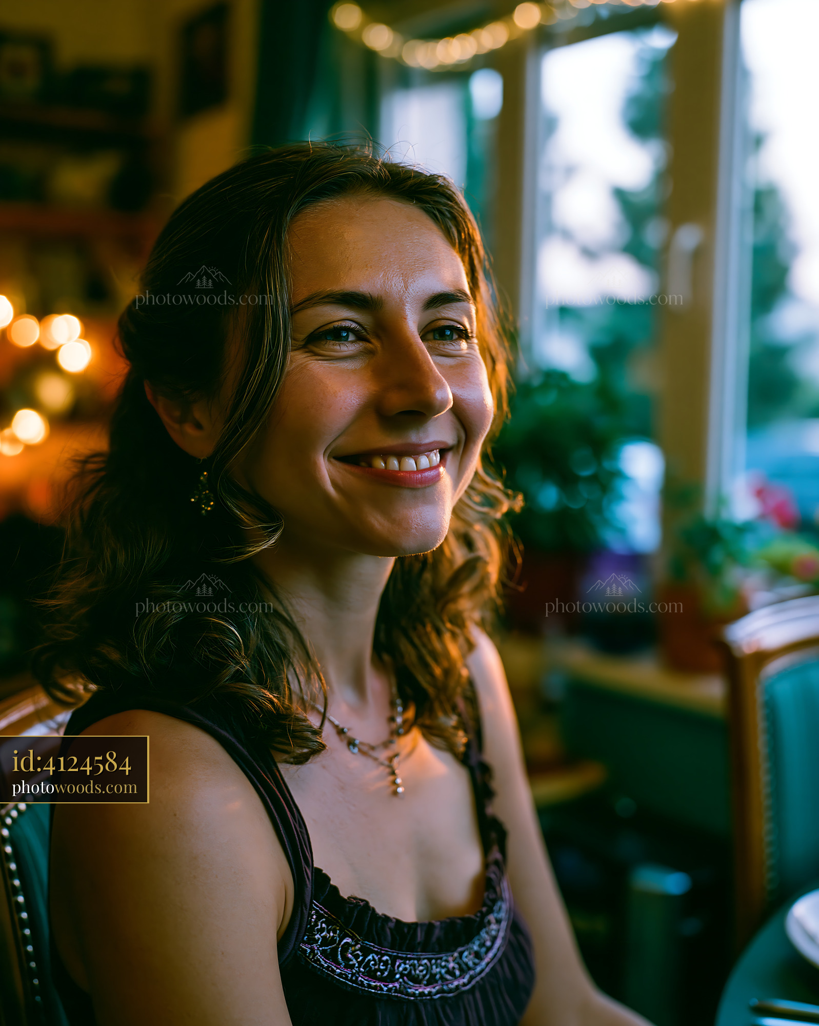 Woman Smiling Indoors With Soft Light and Decorations in Background