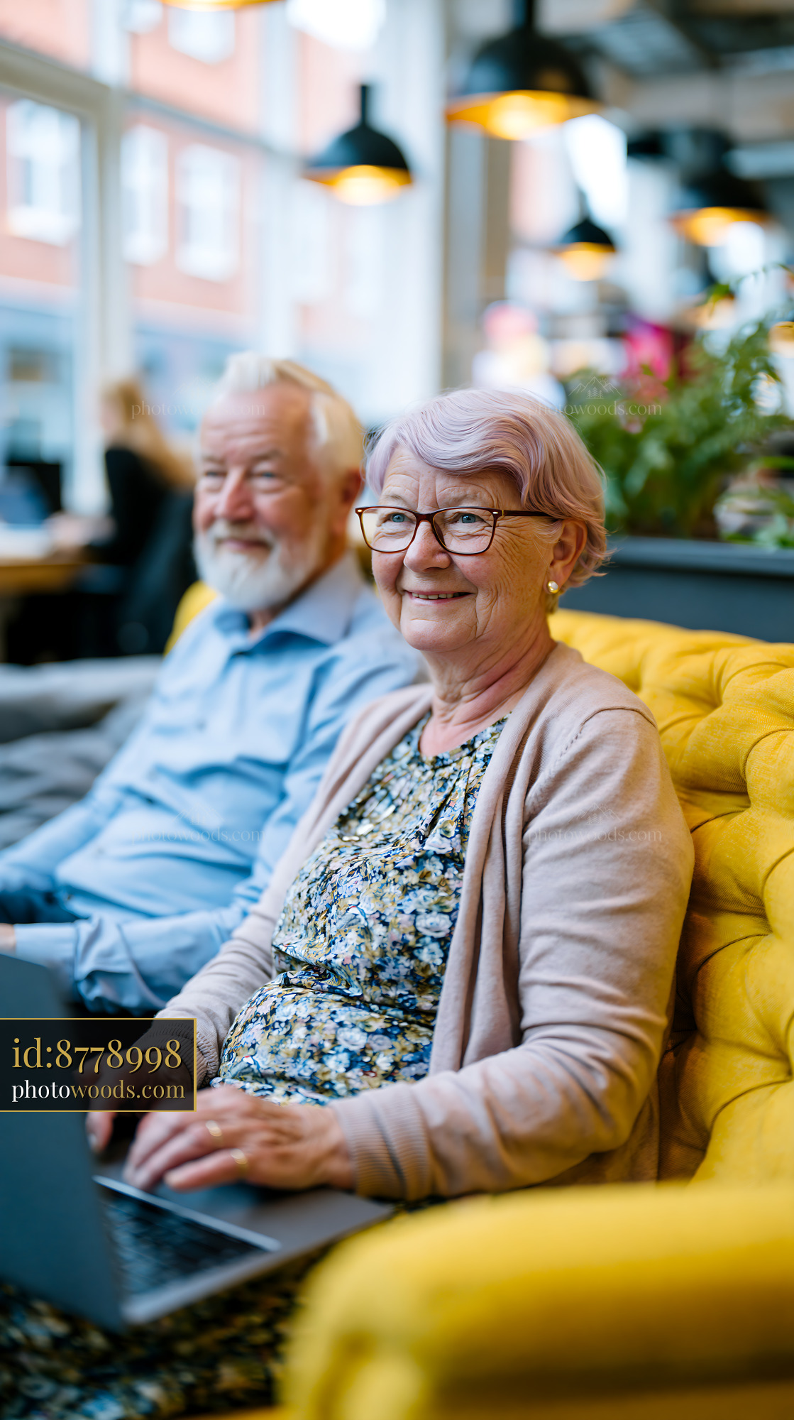 Elderly Couple Working on Laptops in a Modern Cafe