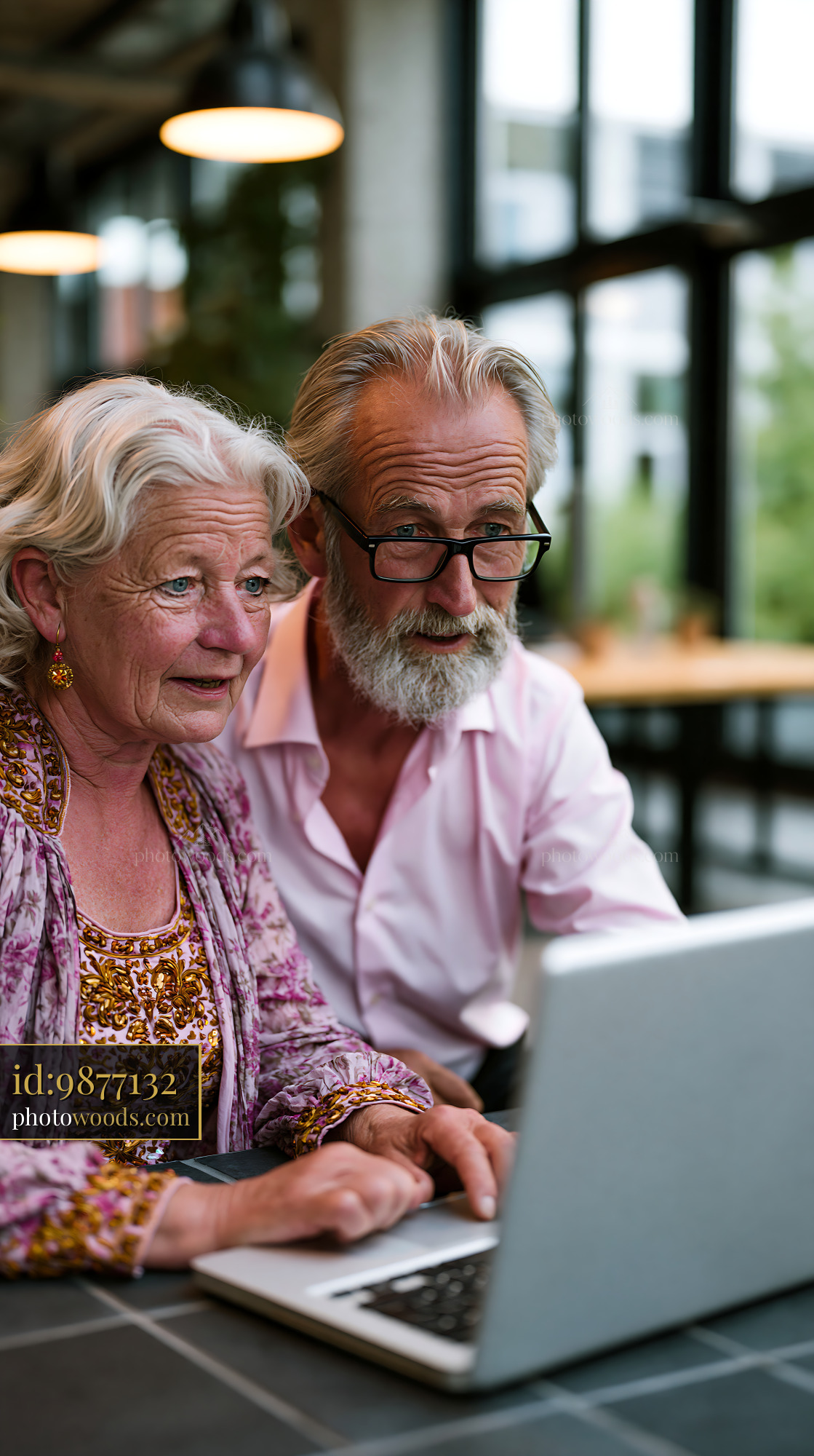 Elderly Couple Working on a Laptop in a Modern Cafe