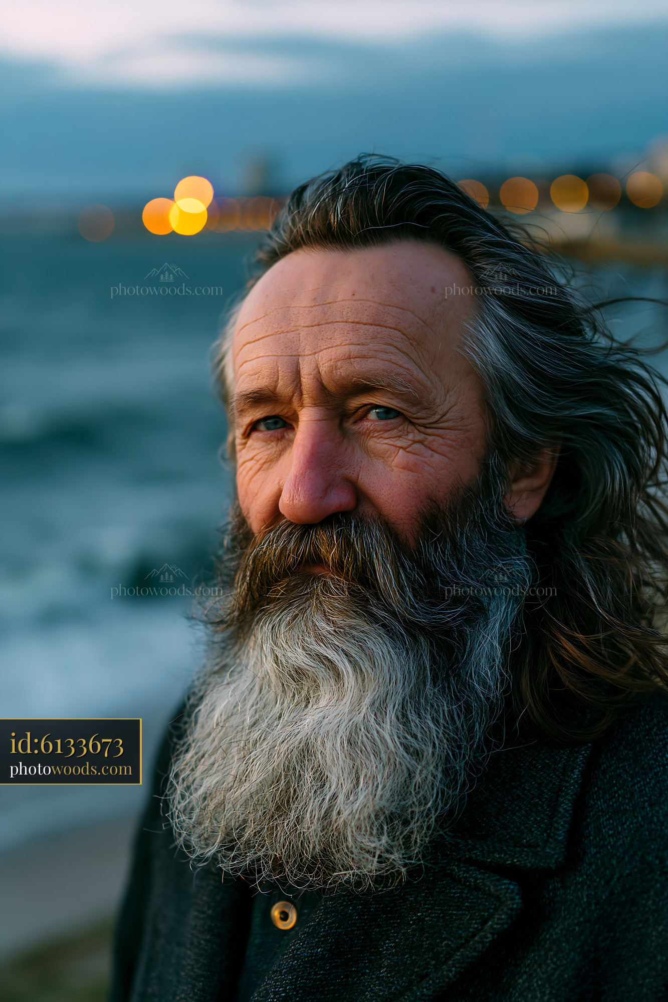 Elderly Man With Gray Beard Standing Near the Ocean at Sunset