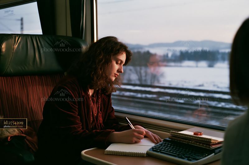 Woman writing a Christmas card on a moving train